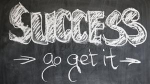 The word "success" written in chalk on a black board 